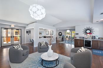 A modern living room with grey chairs and a white coffee table.